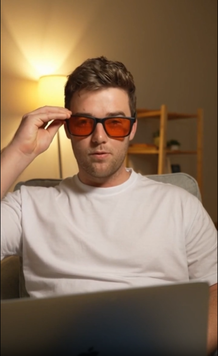  A man wears SleepSpec glasses in the evening, then takes them off and leaves them on the bedside table at lights-out