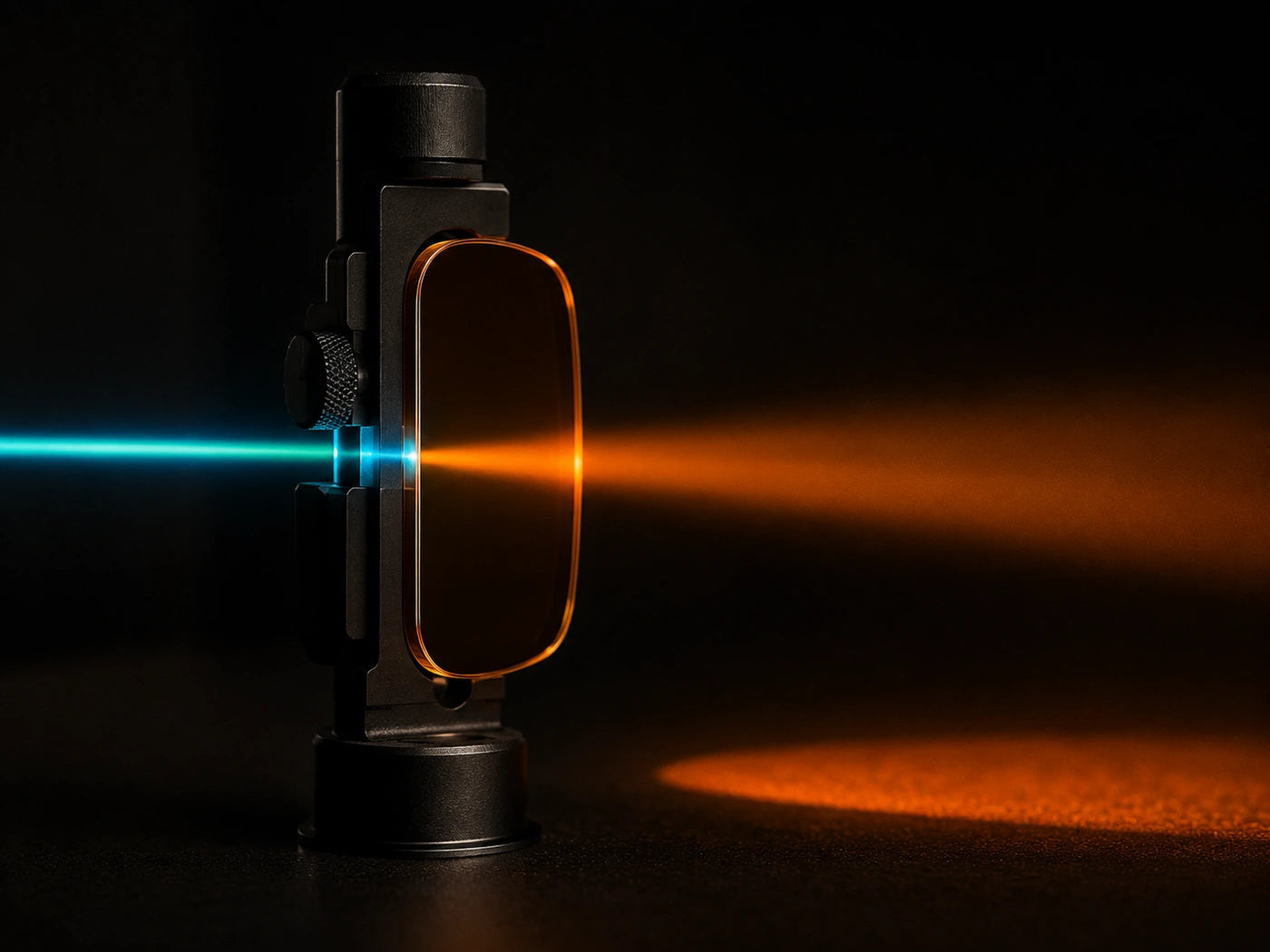 Amber lens held in a spectrophotometer mount: a blue-green beam enters the lens and only amber light continues out the far side
